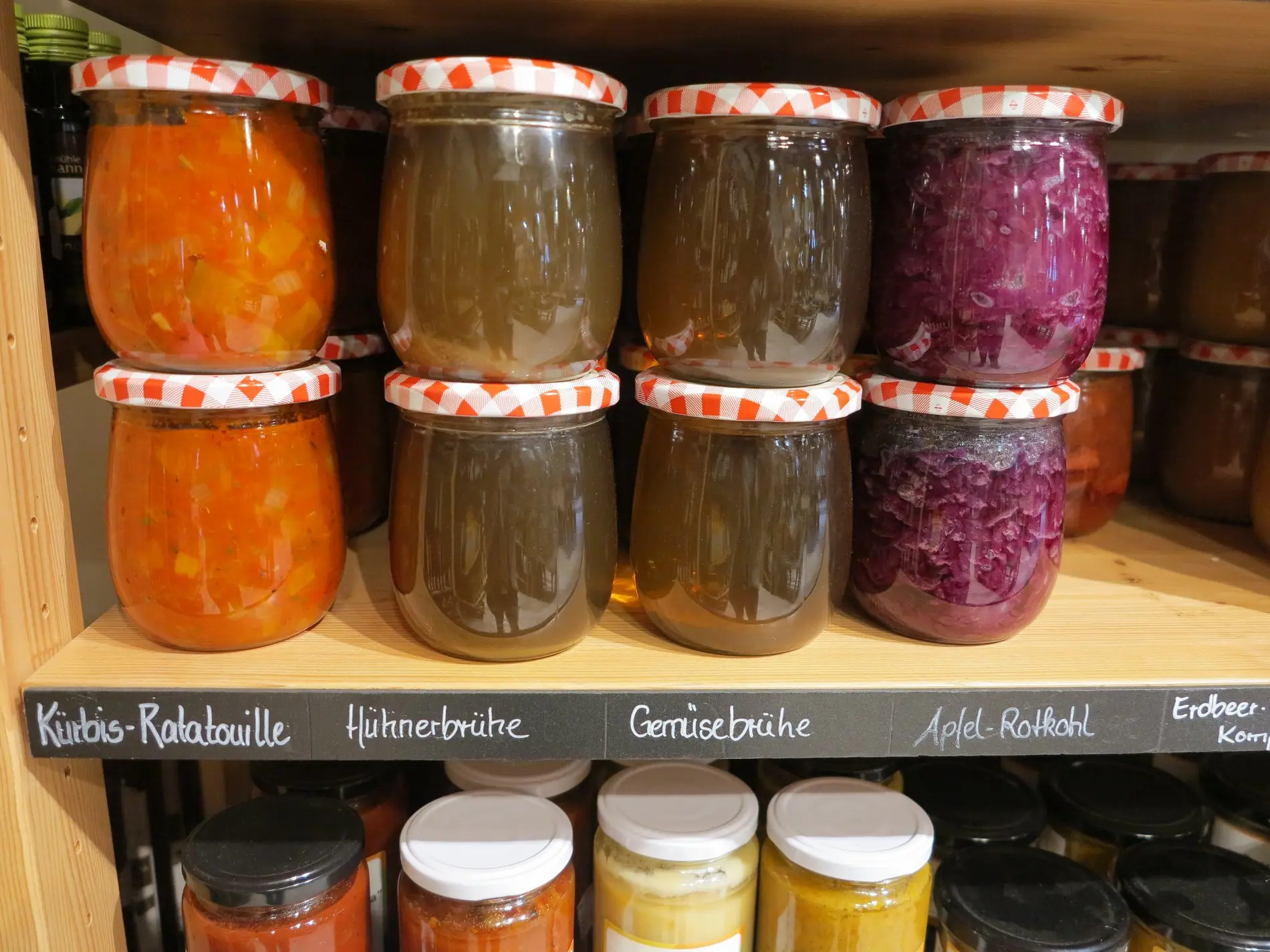 Einmachgläser mit Brühen im Regal.