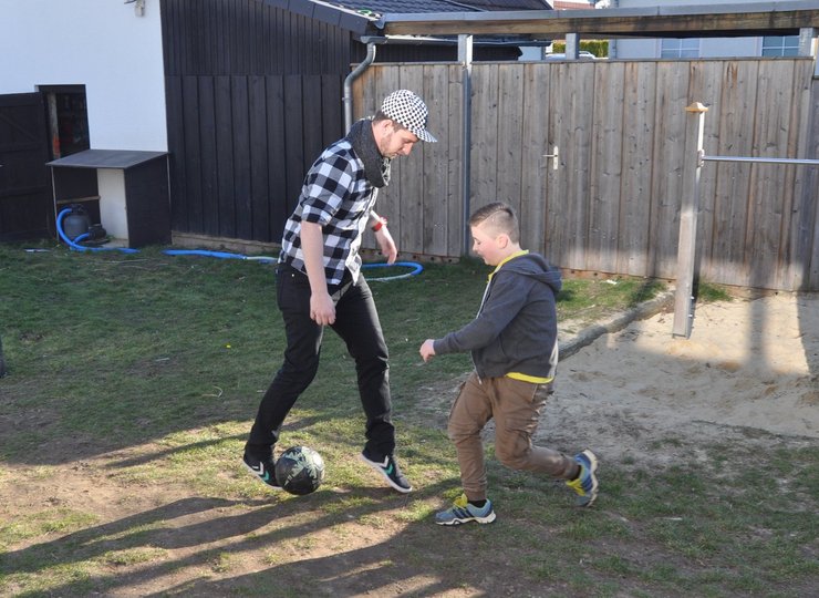 Betreuer Benjamin Lippelt und Benjamin haben Spaß beim Fußballspielen.
