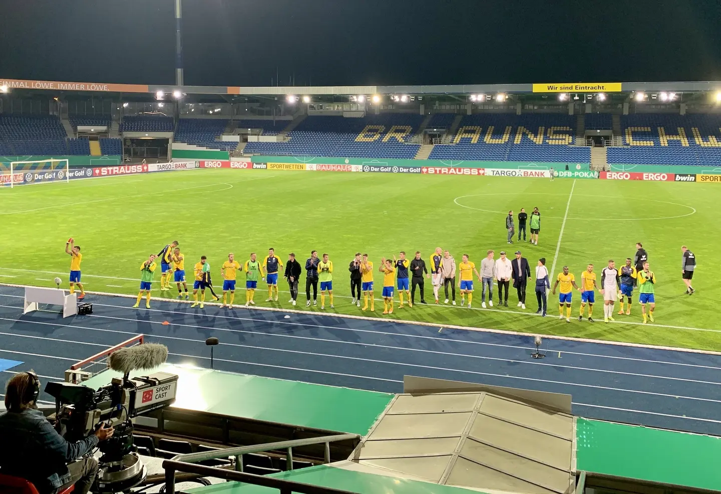 Fußballer und Betreuer auf dem rasen im Braunschweiger Stadion.