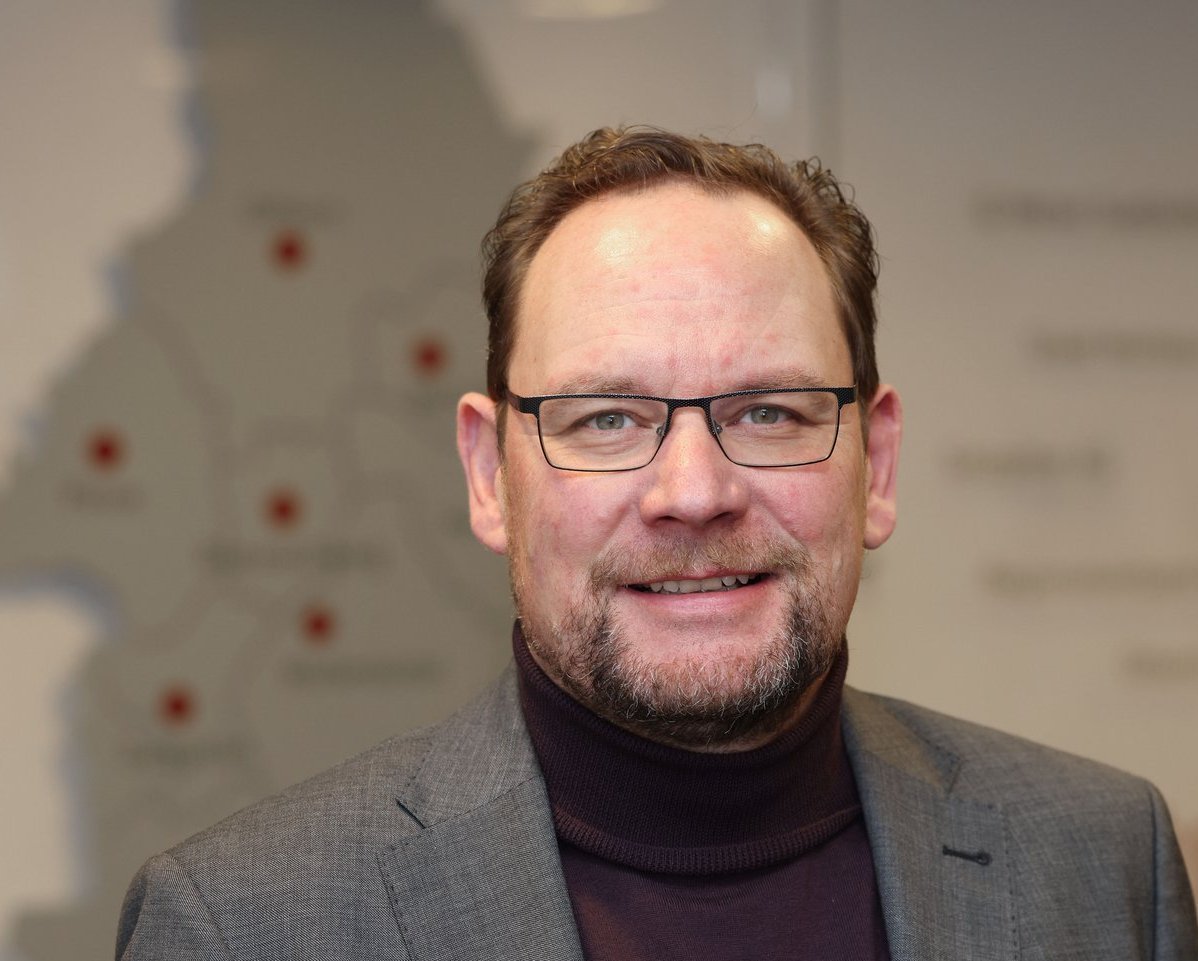 ThomasKrause Porträtbild Thomas Krause vor Landkarte der Region Braunschweig-Wolfsburg