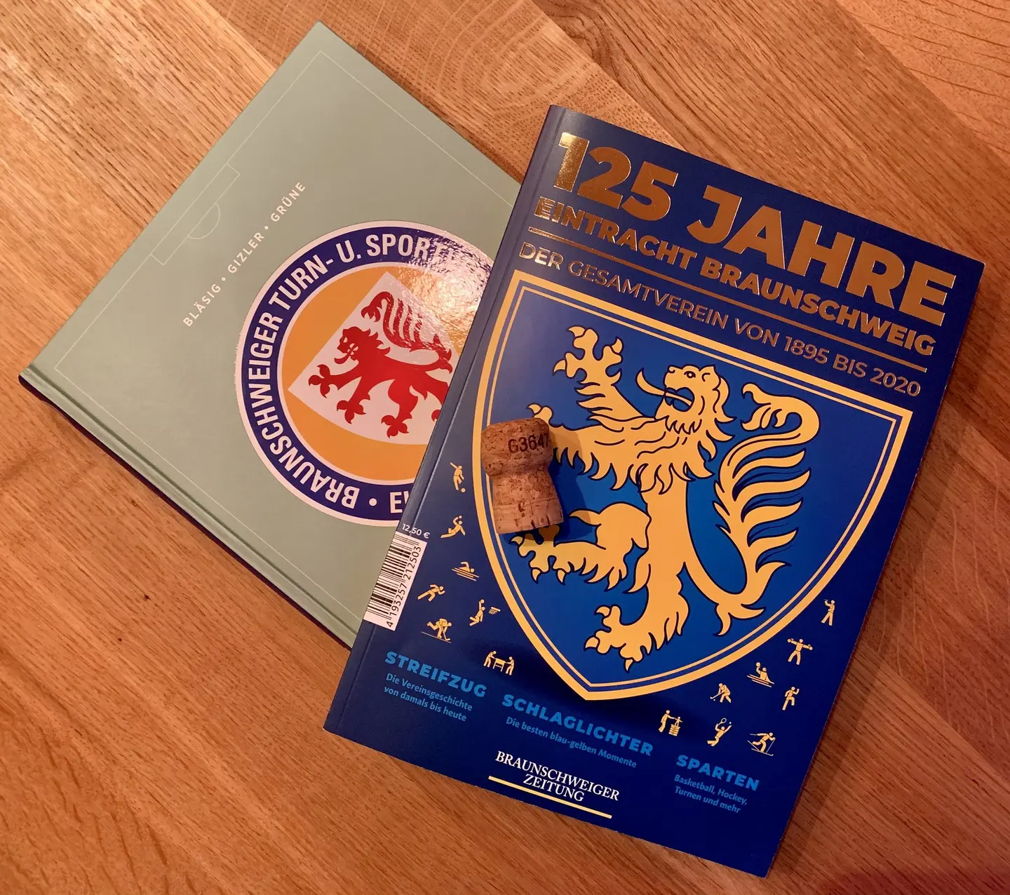 Zwei Hefte und ein Champagnerkorken.