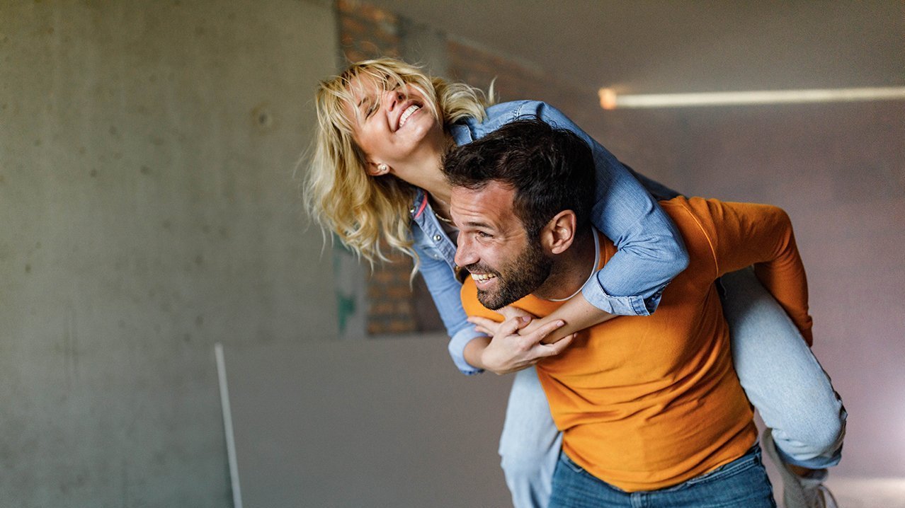 EIn junges Paar in einer Wohnung, sie ziehen gerade ein.