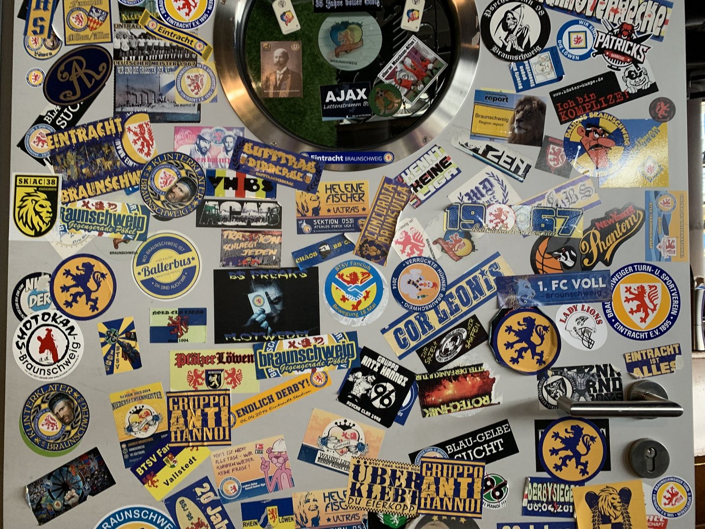 Aufkleber des Fußballvereins Eintracht Braunschweig auf einer Tür in einer Kneipe.