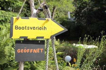 Ein gelbes Schild in Pfeilform an der Floßstation Braunschweig.