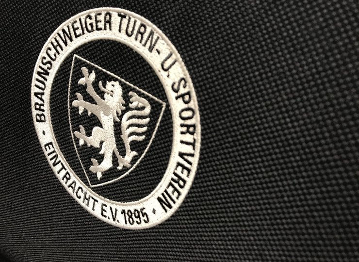 Eine Traditionsmarke: Das Eintracht-Wappen auf einer schwarzen Stuhllehne aus Stoff..