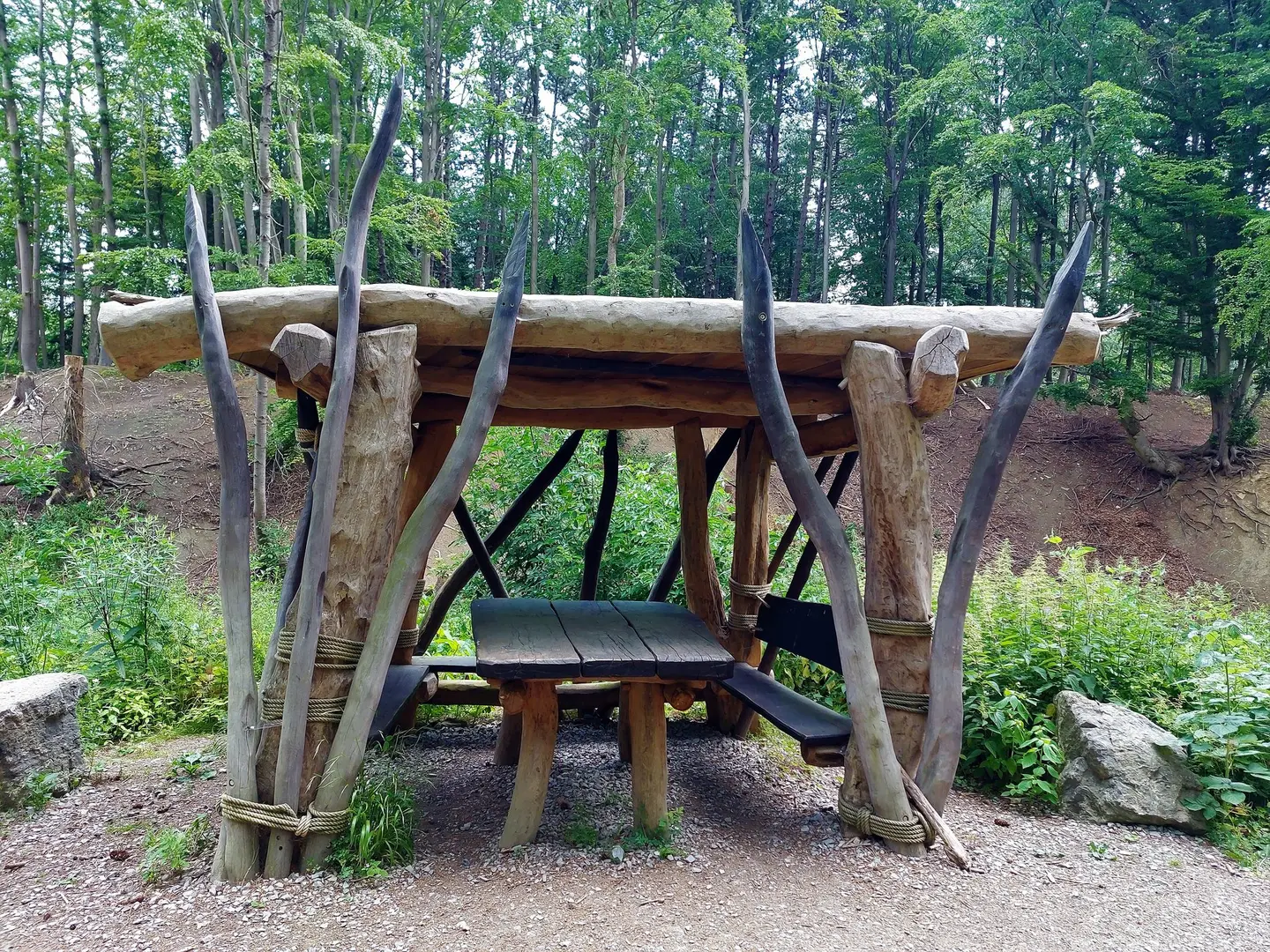 Eine Holzhütte mit altertümlichen Speeren rechts und links des Eingangs.