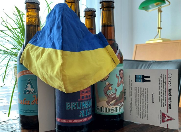 Bierflaschen und ein blaugelber Mundschutz.