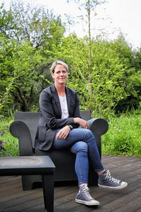 Eine Frau sitzt auf einem Gartenstuhl.