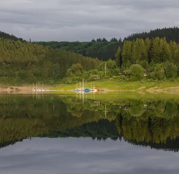 Der umgebende Wald spiegelt sich in der Wasseroberfläche des Okerstausees. (Bildrechte: Marvin Reepschläger)