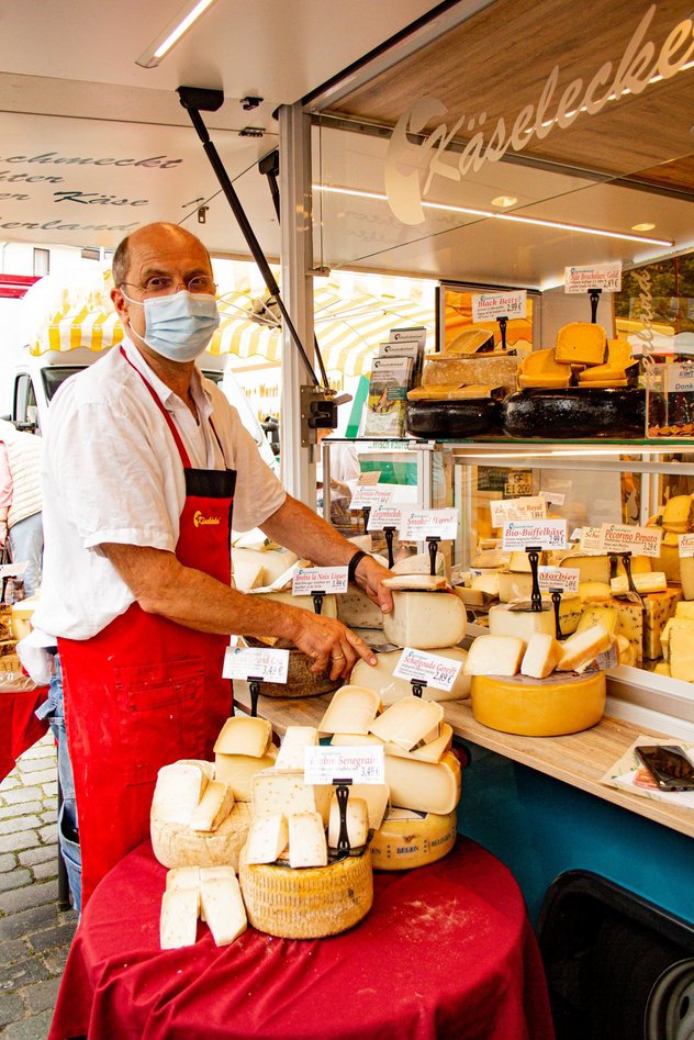 Ein Käsehändler an seinem Marktstand.