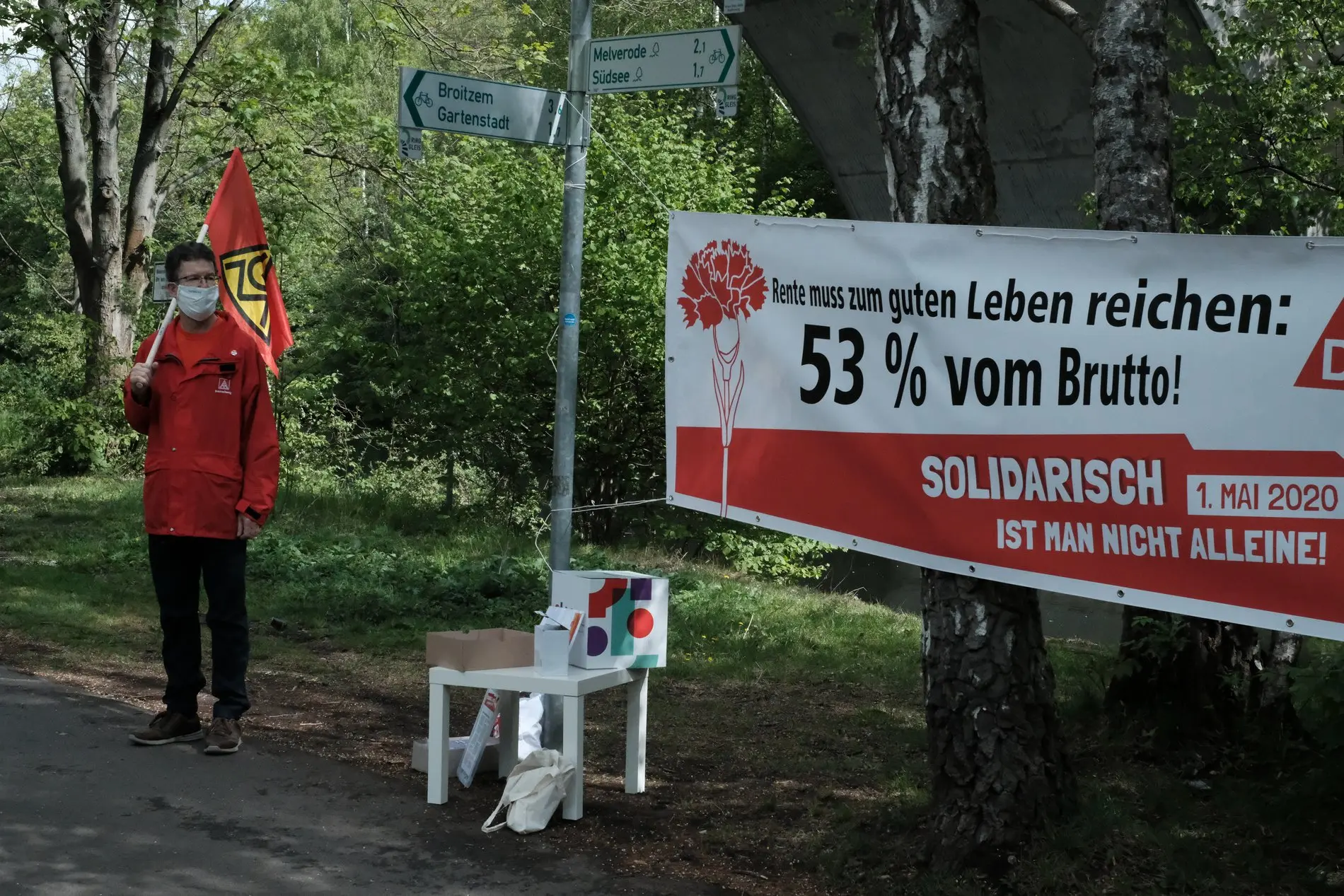Ein Gewerkschaftler steht links neben einem Plakat.