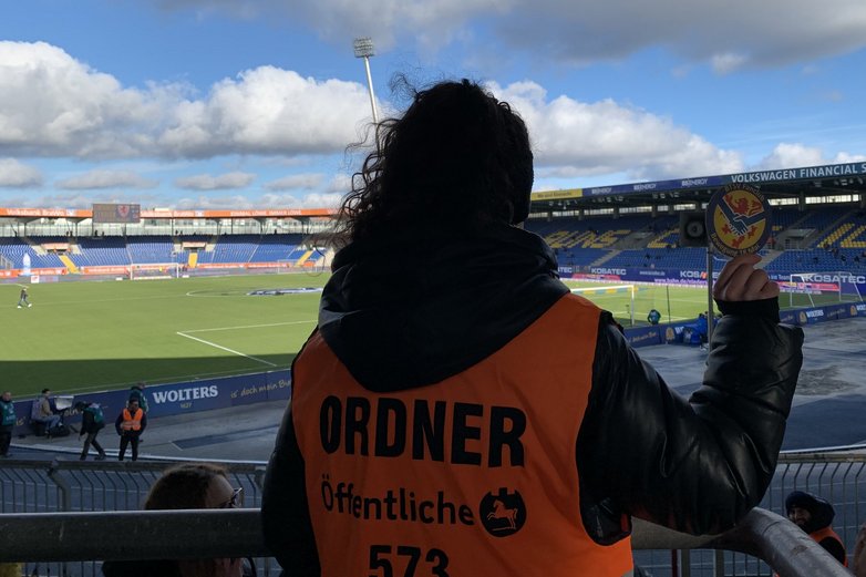 Die junge Ordnerin und unser Fanclub-Bierdeckel.