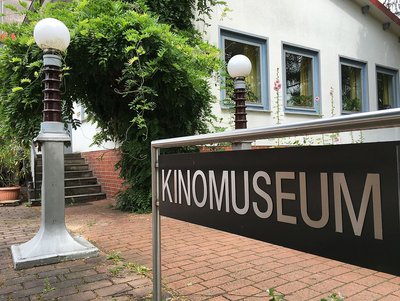 Man sieht das Schild am Eingang zum Kinomuseum