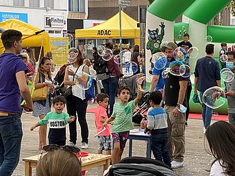 Abgebildet ist ein Straßenfest für Kinder.
