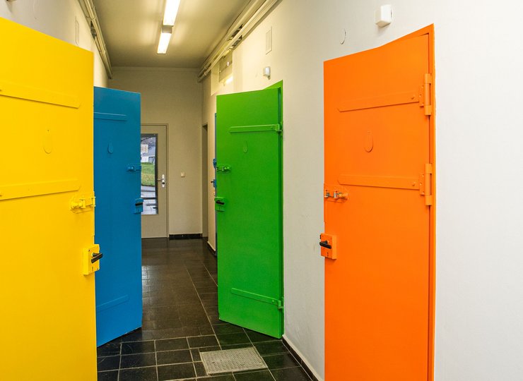 Ein Gang mit vier verschiedenfarbigen Türen. 