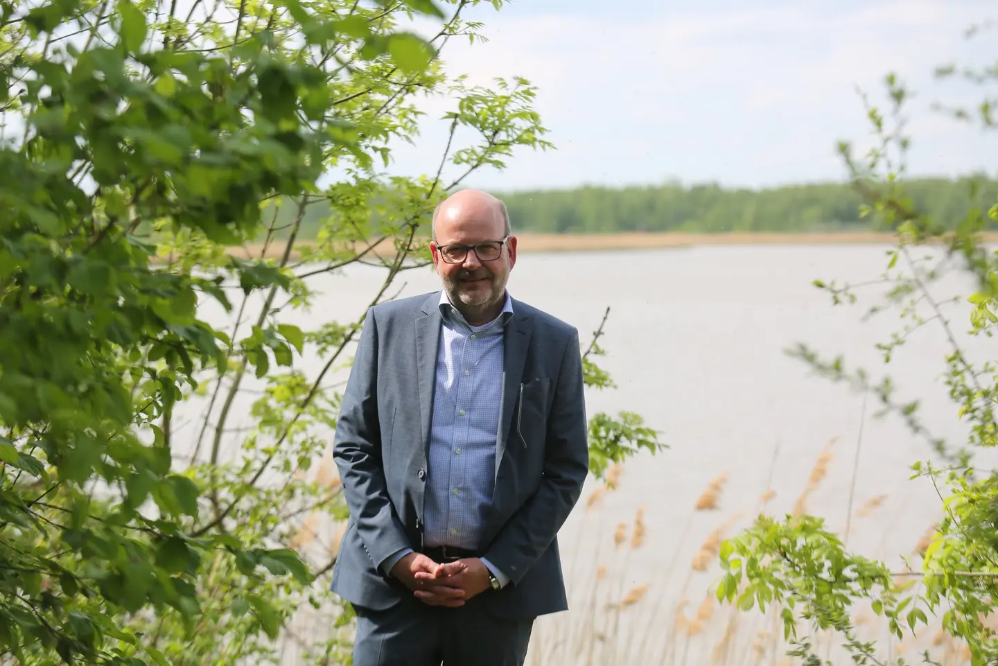 Ein Mann steht vor einem See.