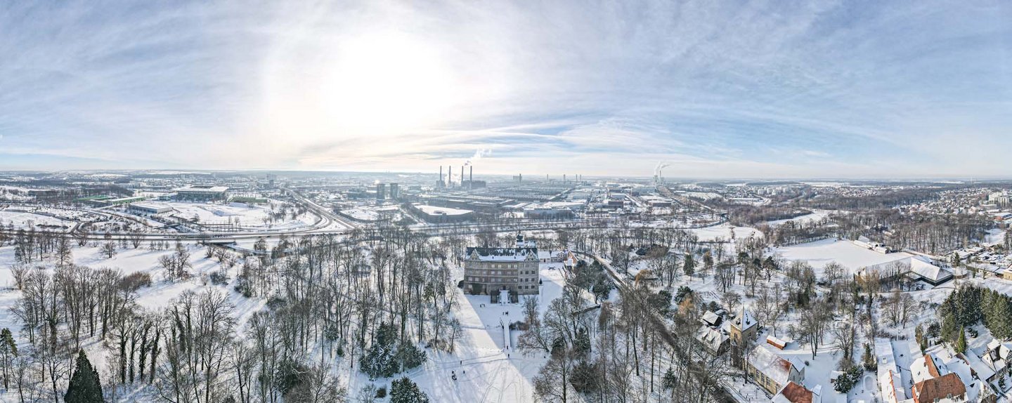 Man blickt aus der Luft in einer Panoramasicht auf das winterliche Wolfsburg