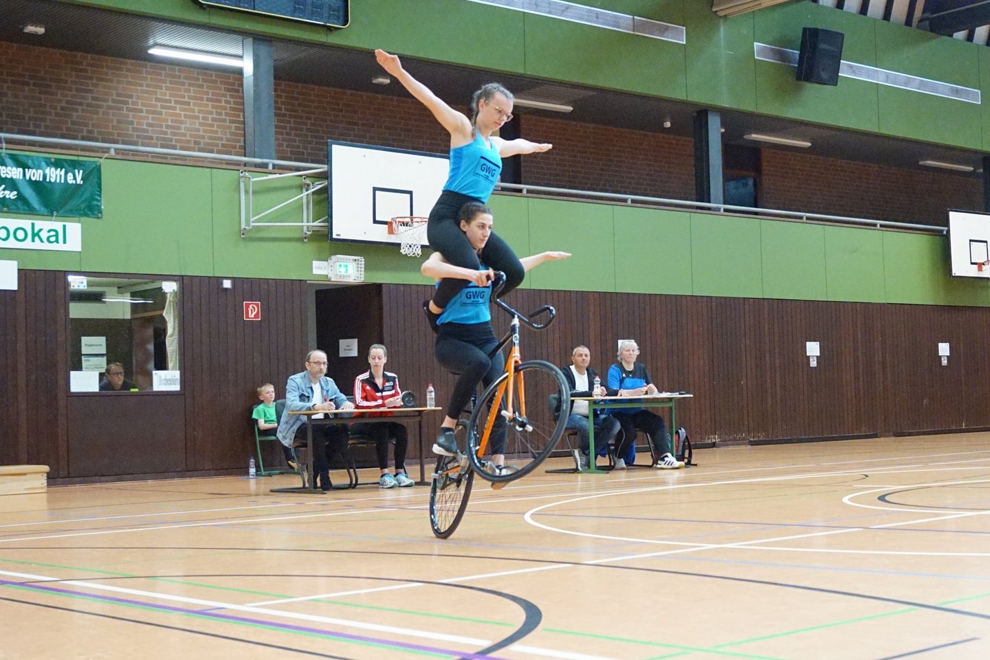 Zwei junge Frauen sitzen übereinander auf einem Fahrrad.