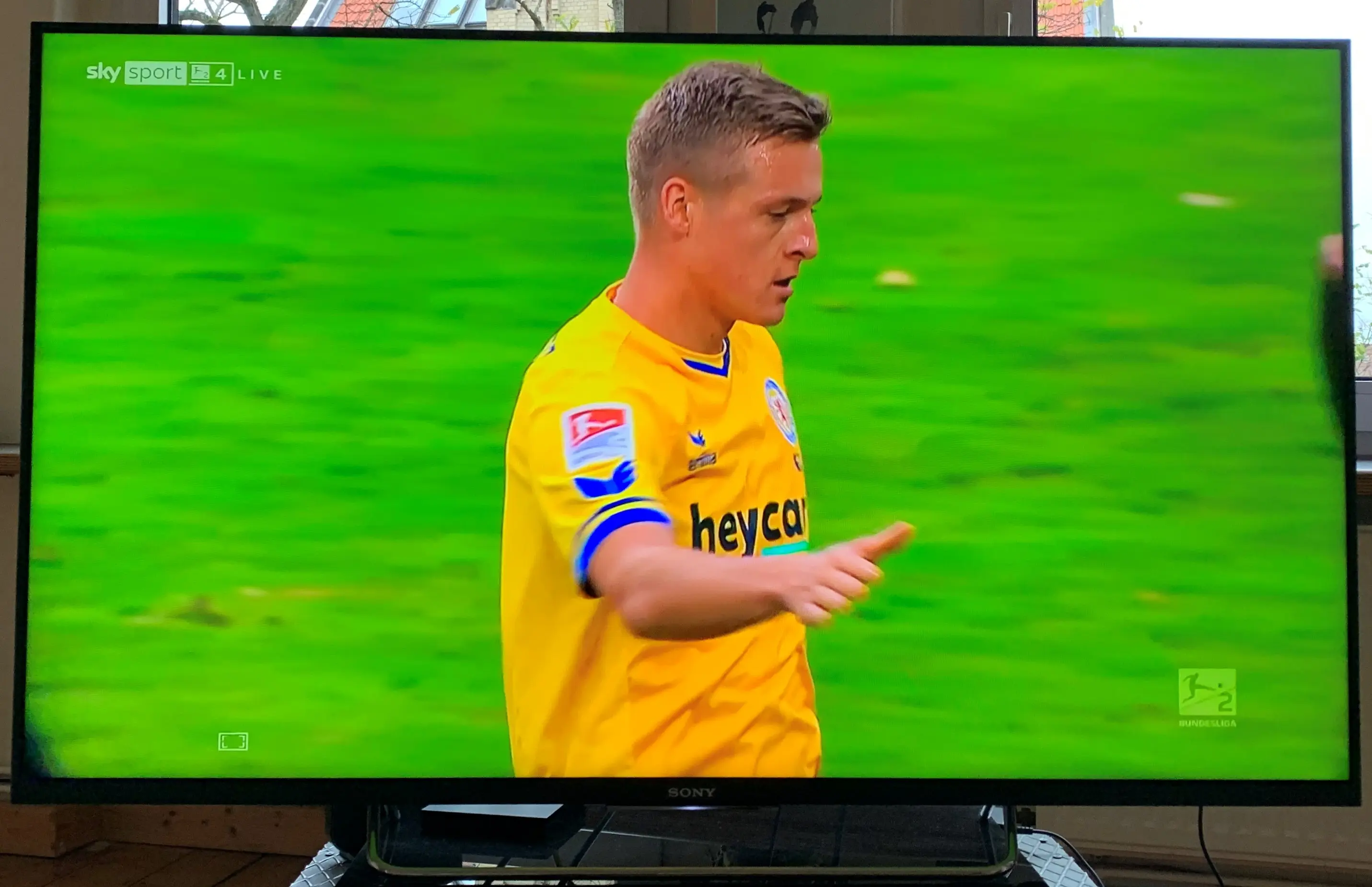 Ein Fußballer im gelben Trikot.