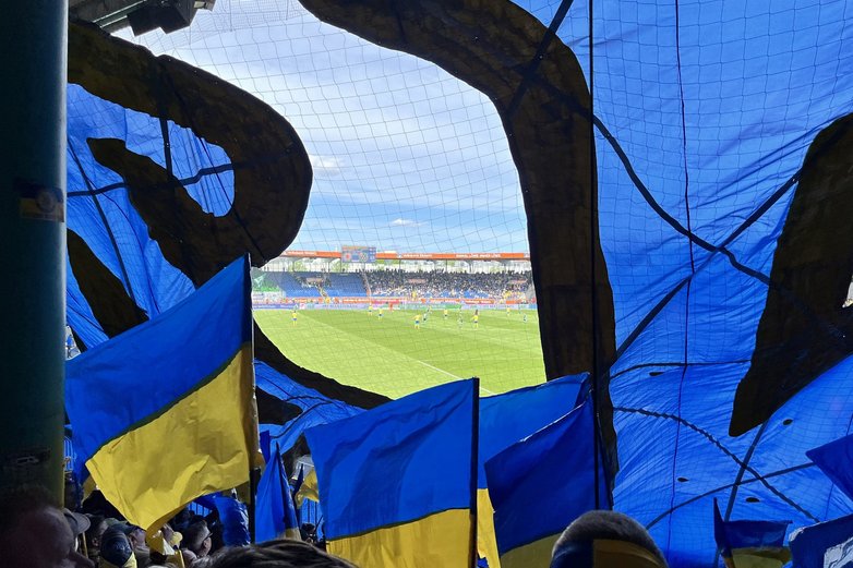 Blick aus auf das Spielfeld zwischen Fan-Fahnen.