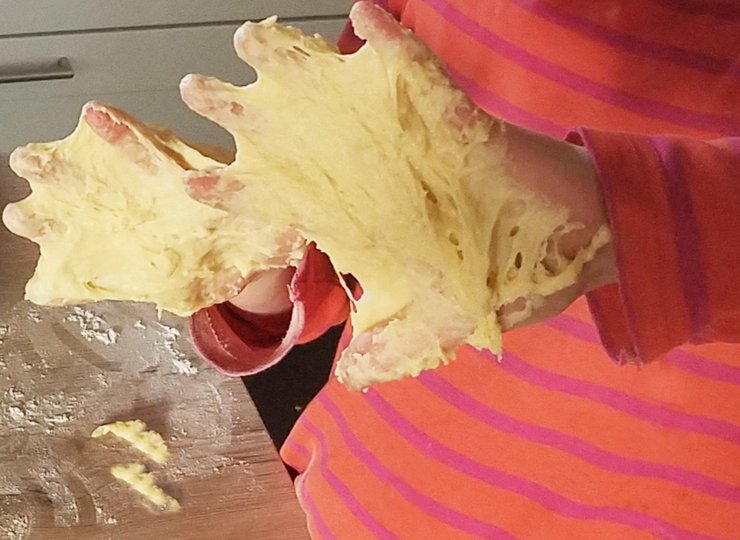 Mit Teig beschmierte Kinderhände