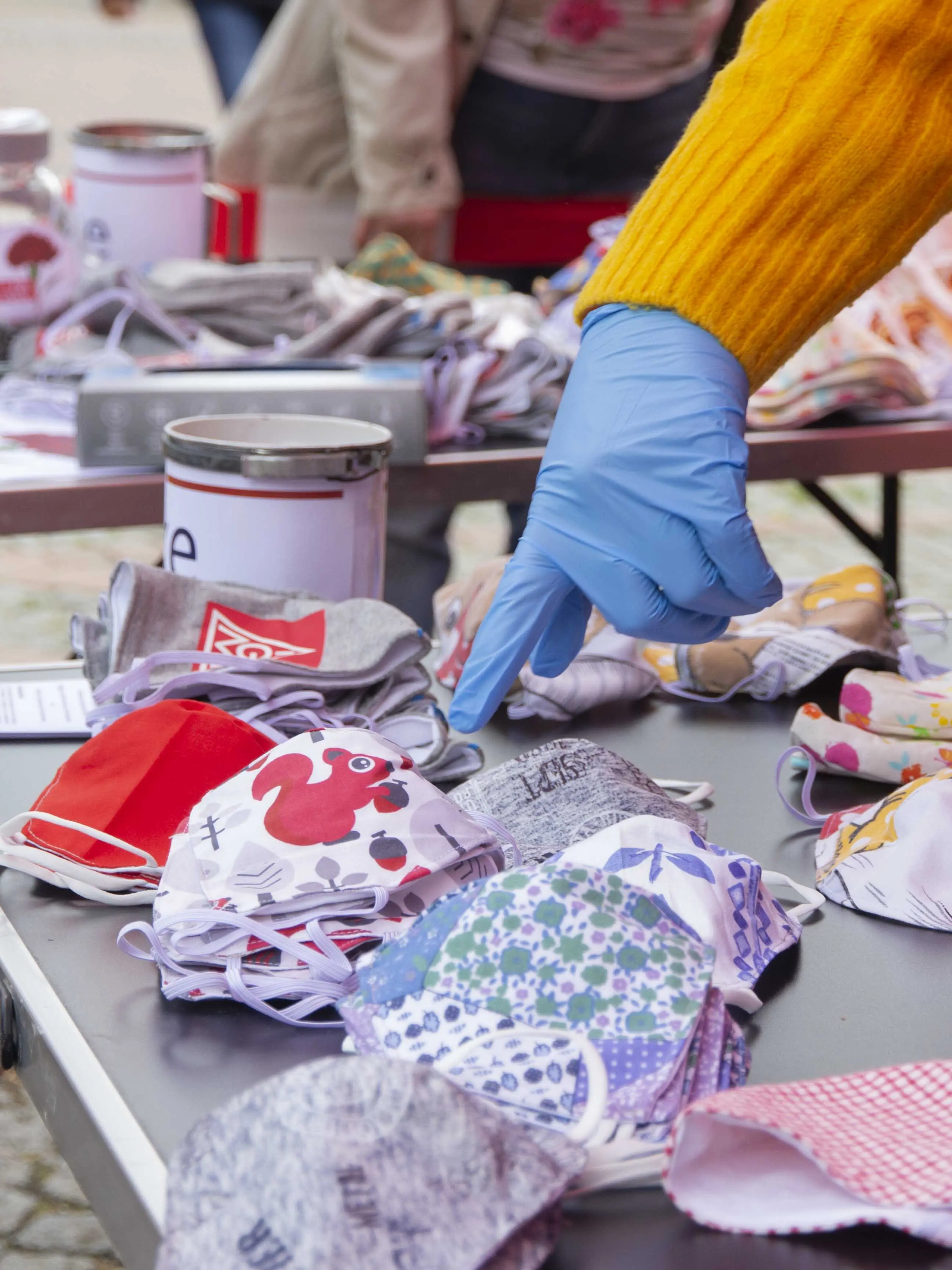 Ein Finger zeigt auf einen Mundschutz, auf dem ein rotes Eichhörnchen abgebildet ist.