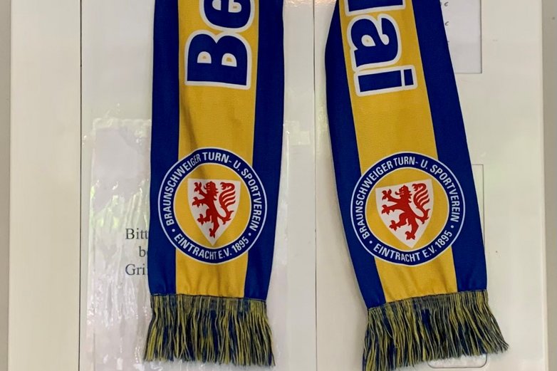 Über einem Bier-Automaten hängt ein Eintracht-Schal, oben drauf steht eine Flasche Haller Löwenbräu.