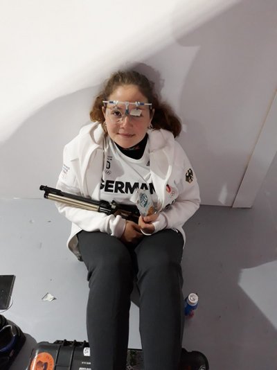 Sportschützin Vanessa Seeger sitzt auf dem Boden und trägt die Sportschützenbrille.