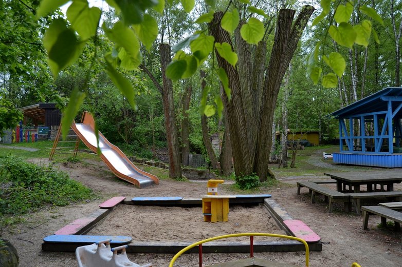Rutsche und Sandkasten auf dem  Abenteuerspielplatzes Melverode in Braunschweig im Sommer. 