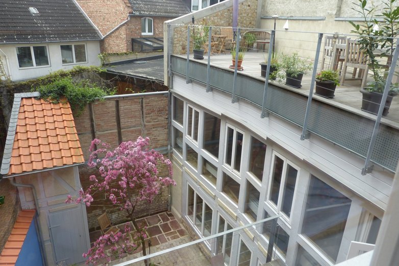 Blick auf den Innenhof mit Fenstern und Blumen eines Hauses in Helmstedt.