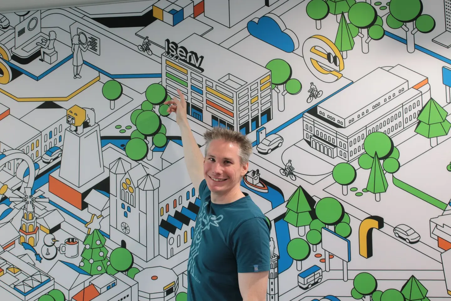 Ein Mann zeigt auf ein Bild hinter ihm. 