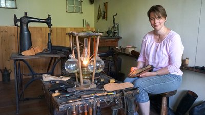 Man sieht Museumsleiterin Ulrike Wendt-Sellin in der Schusterwerkstatt des Museums Burg Brome