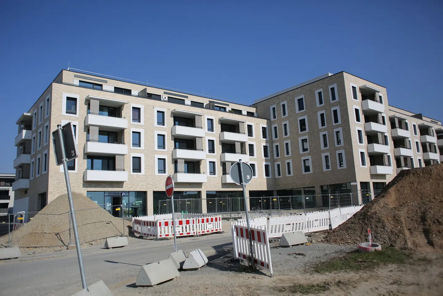 Ein Appartementkomplex vor einer Baustelle.