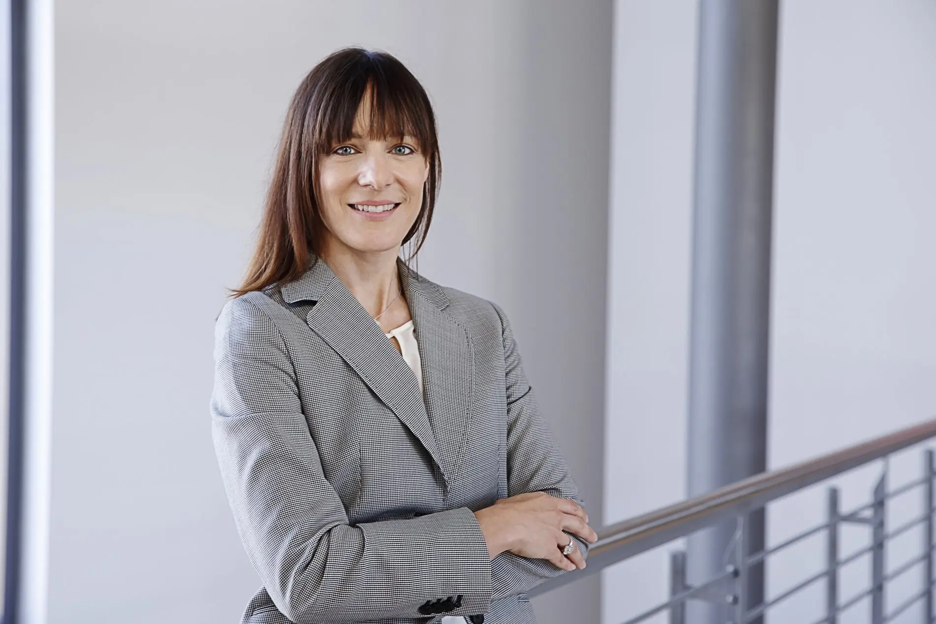 Eine Frau im grauen Blazer.