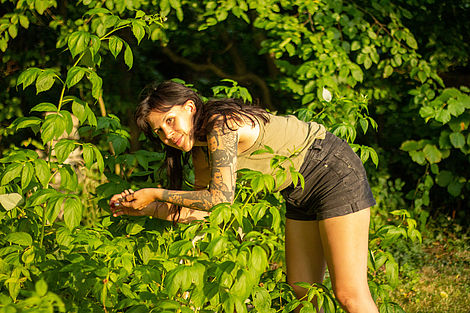 Eine junge Frau pflückt Beeren.