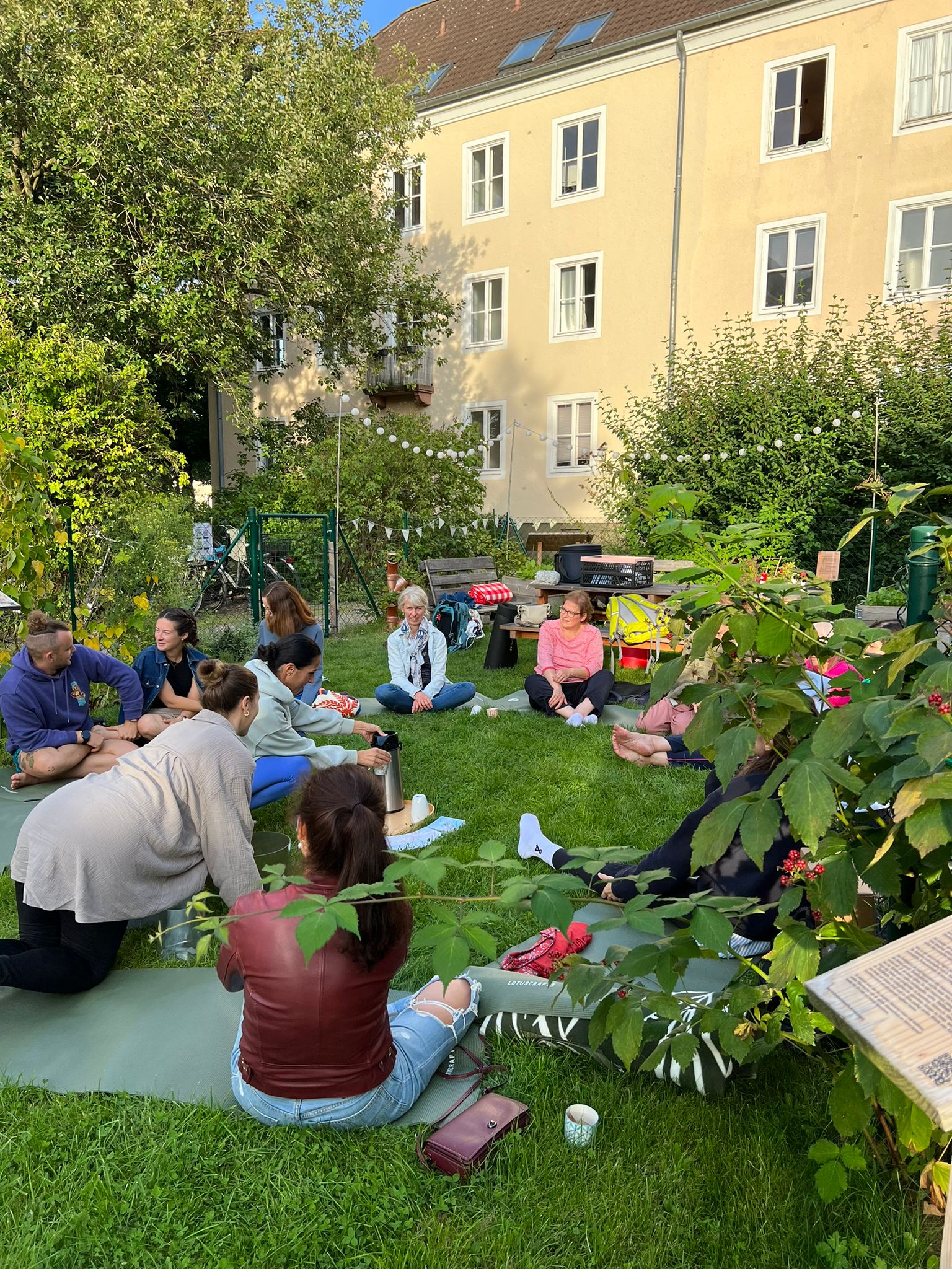 Ökologischer Fußabdruck: Eine Gruppe Menschen sitzt auf dem Rasen im Kreis.