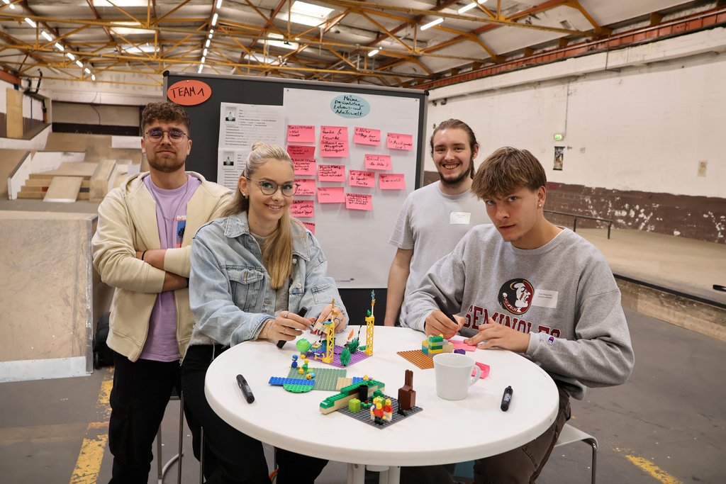 Gen-Z steht im Workshop um einen Tisch