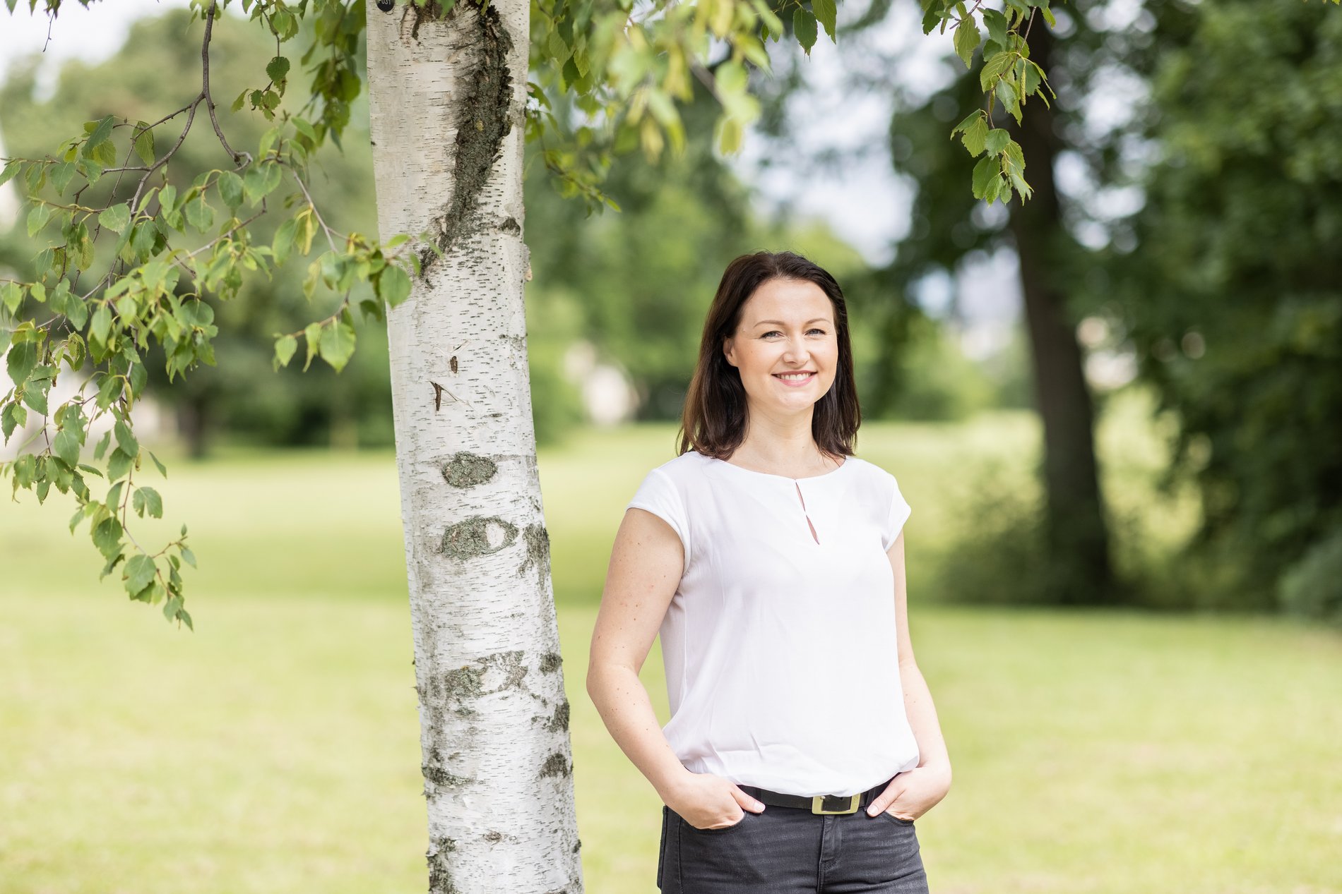 Eine Frau steht vor einer Weide.