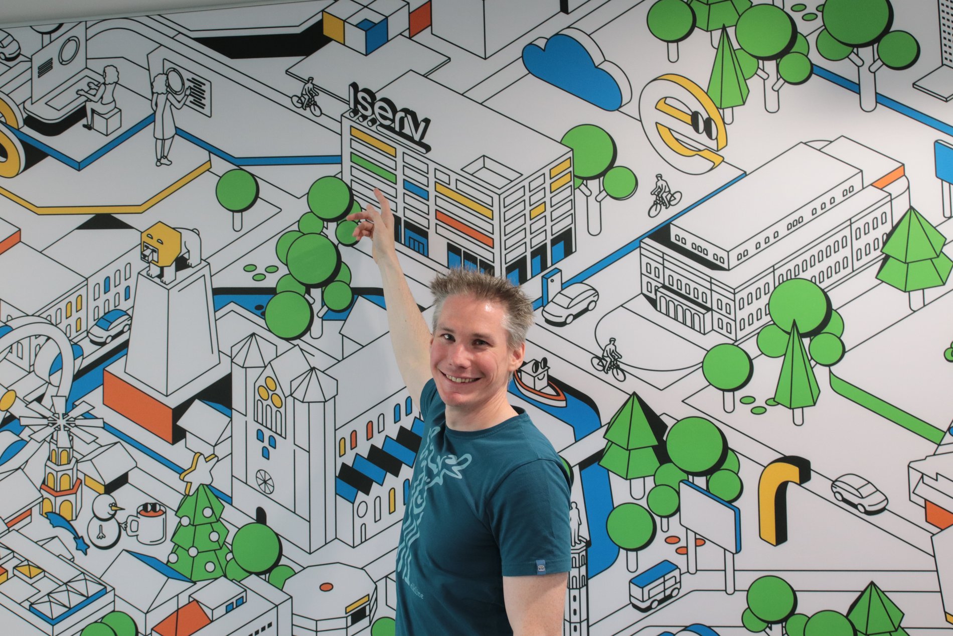 Ein Mann zeigt auf ein Bild hinter ihm. 