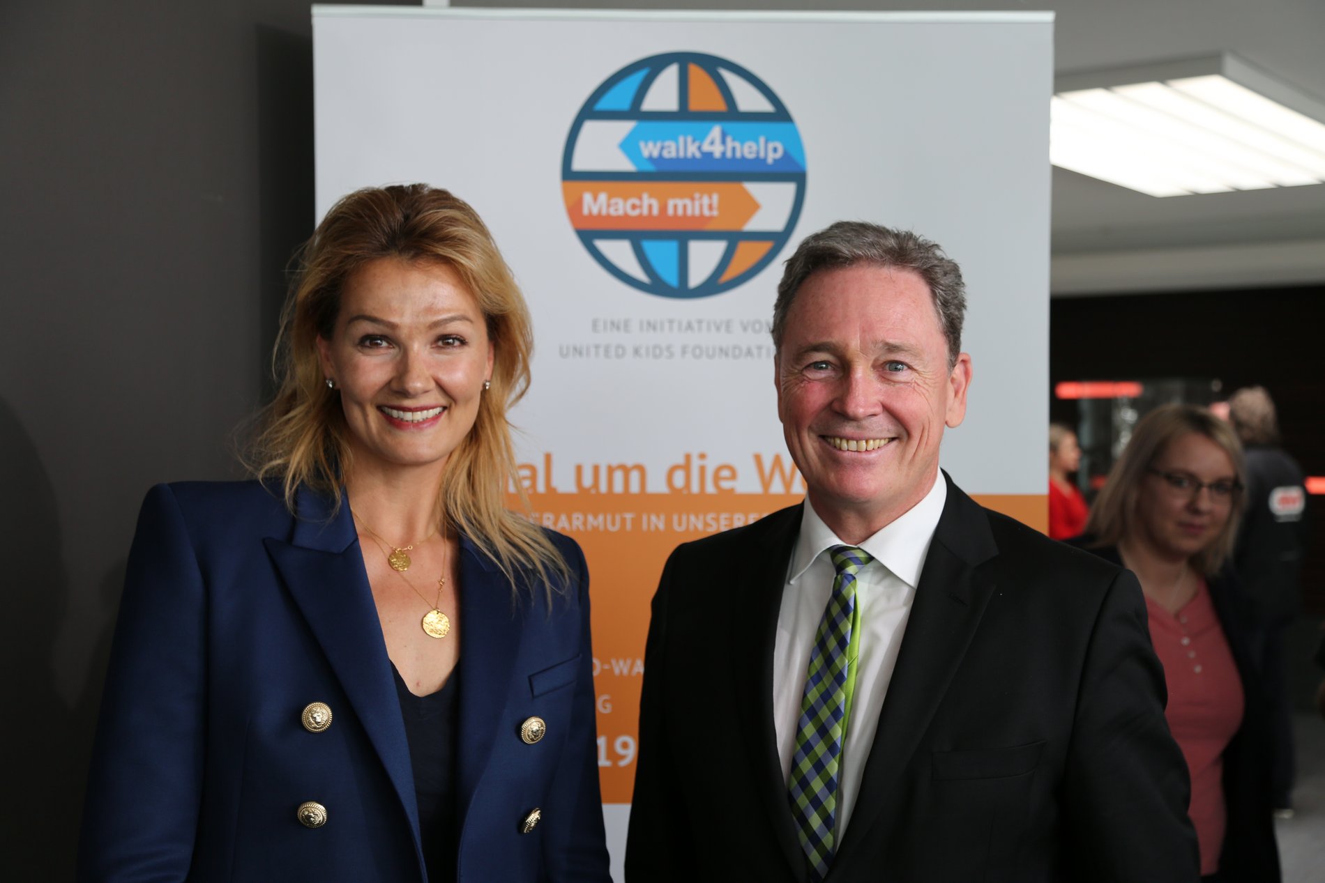 Franziska van Almsick und Thomas Fast vor einem Banner von walk4help.