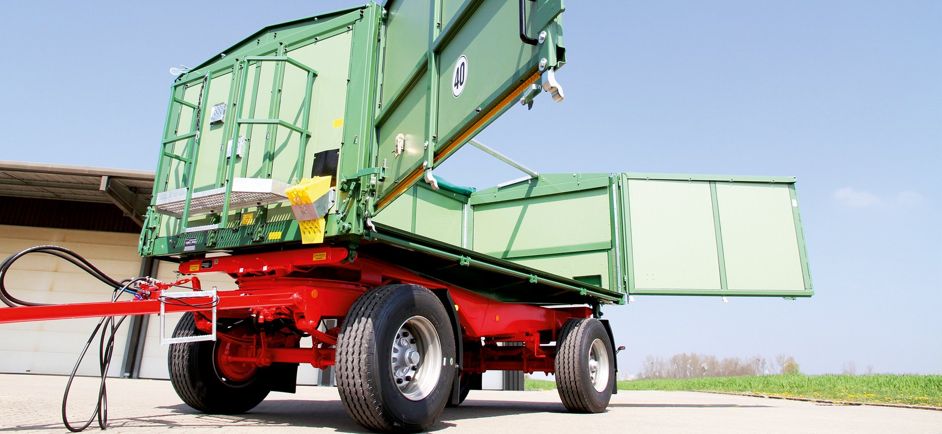Ein grün-rotes Fahrzeug der Rudolph & Sohn GmbH in Salzgitter-Heerte bei Sonne und blauem Himmel.