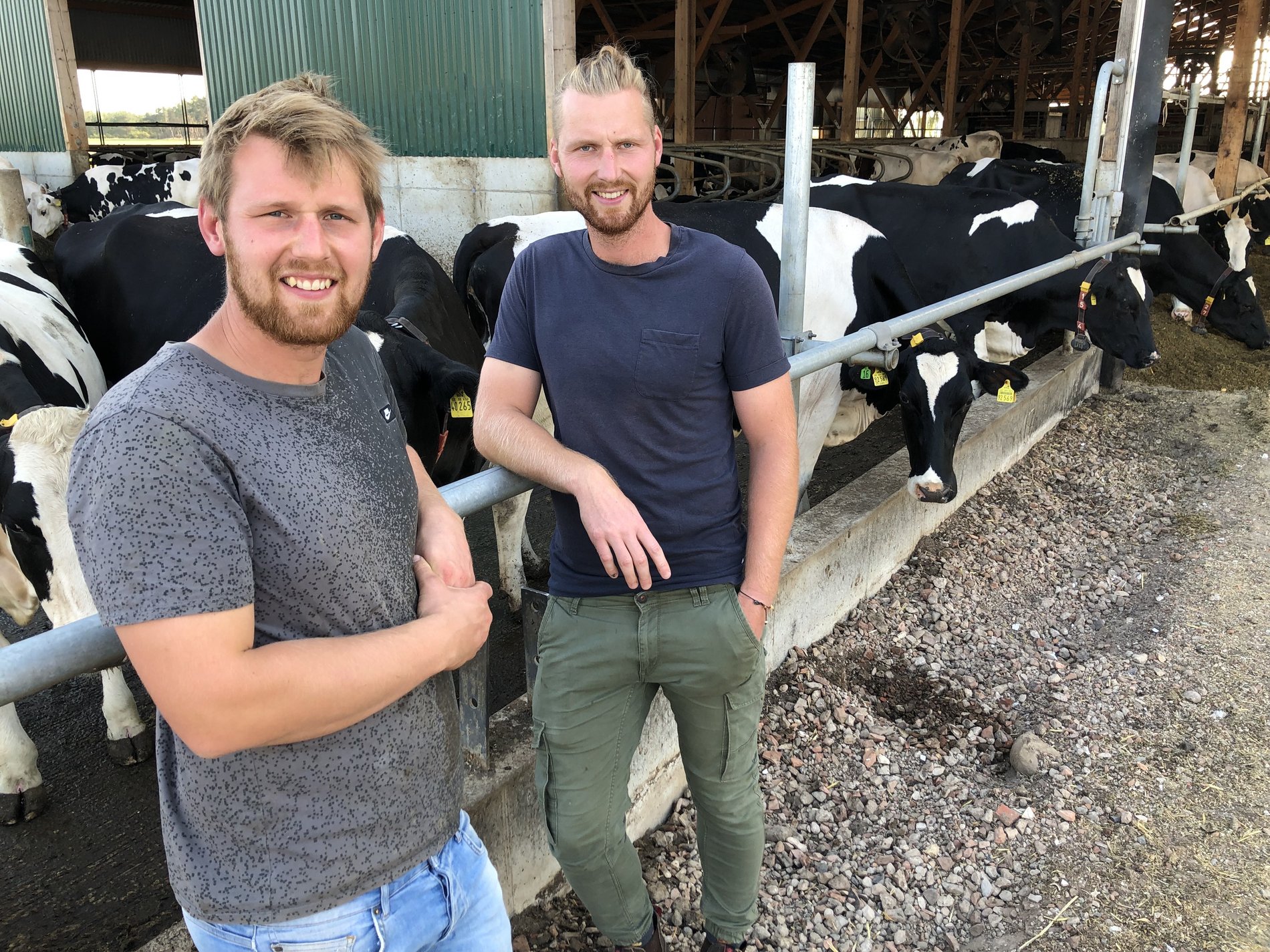 Zwei Bauern vor ihrem Kuhstall.