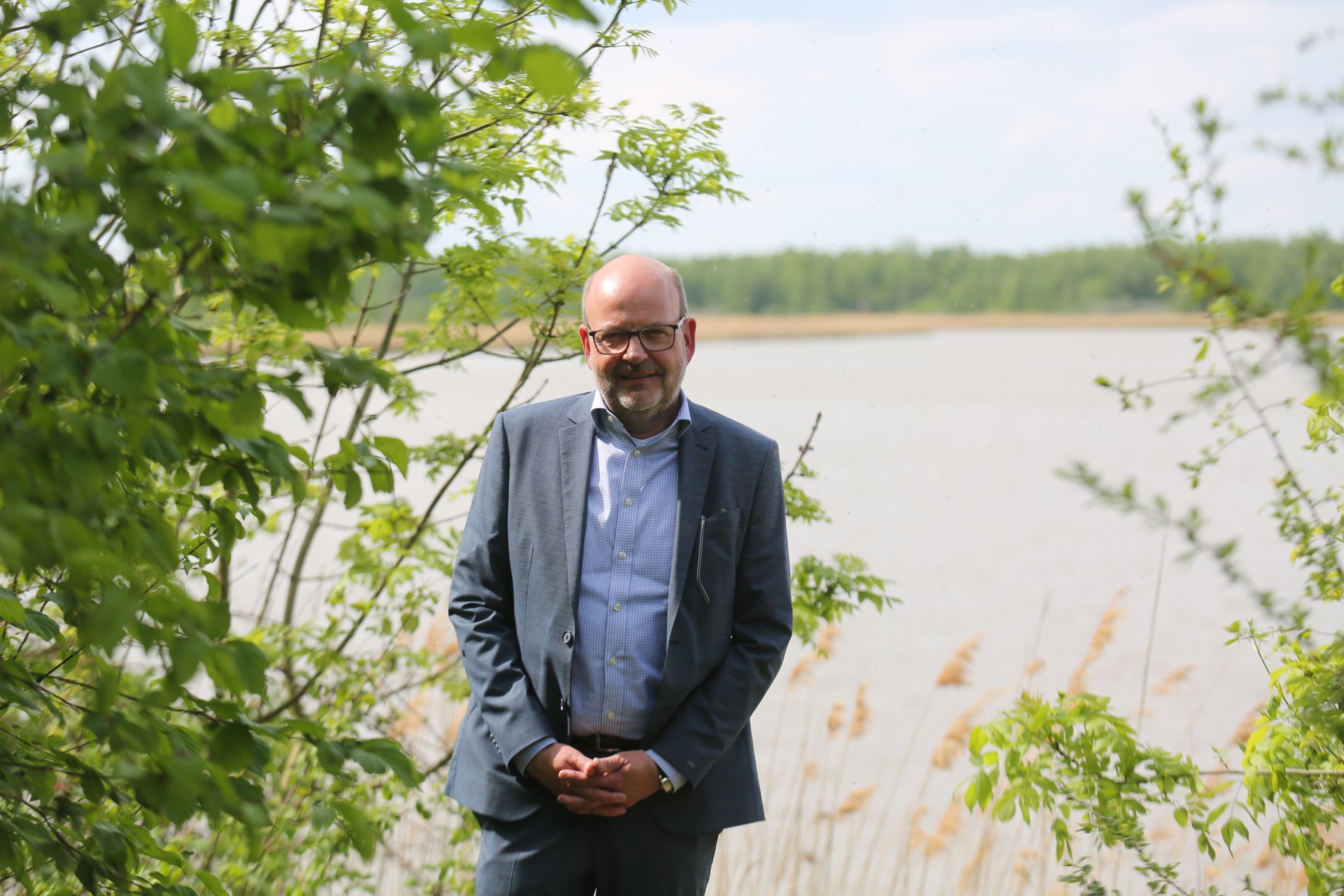 Ein Mann steht vor einem See.