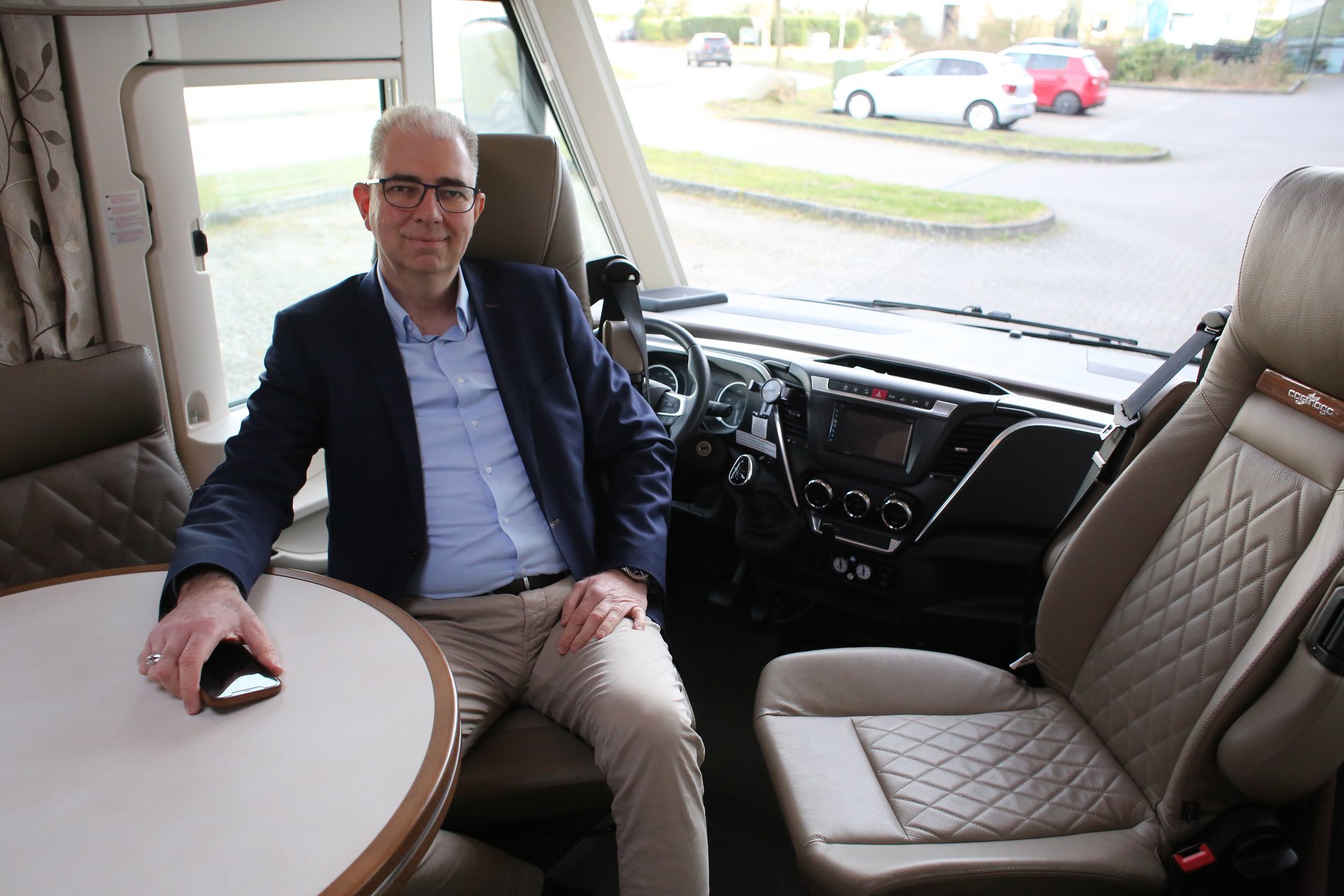 Ein Mann sitzt hinter dem Steuer eines Wohnmobils.