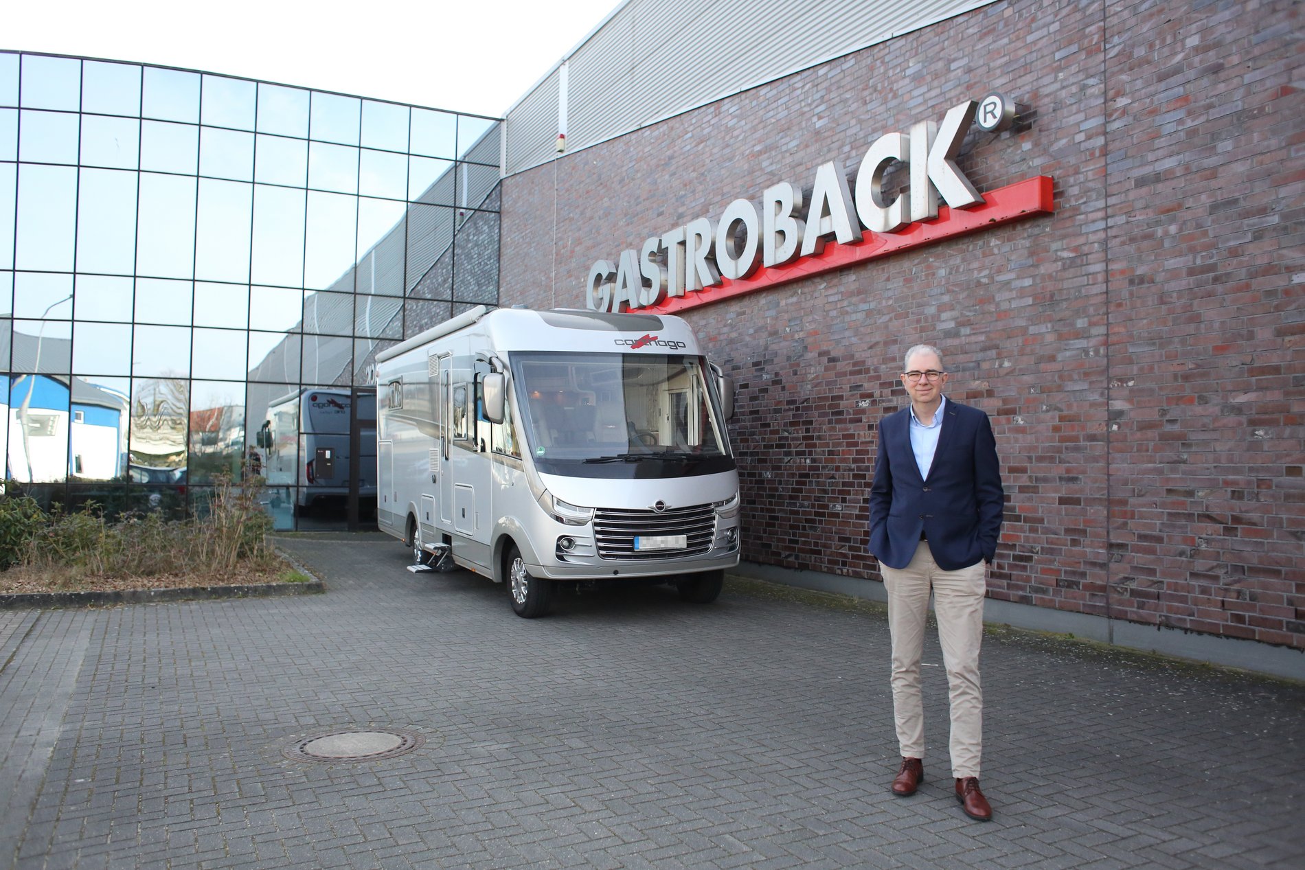 Ein Mann steht vor einem Wohnmobil.