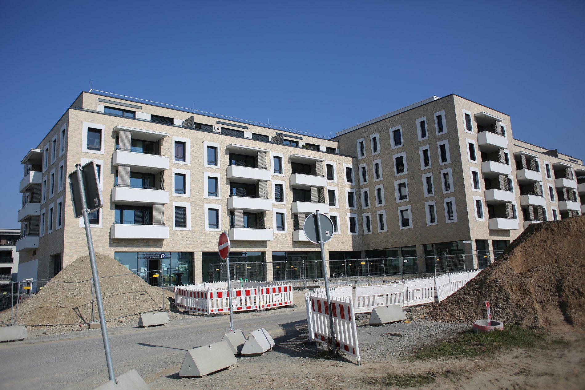 Ein Appartementkomplex vor einer Baustelle.