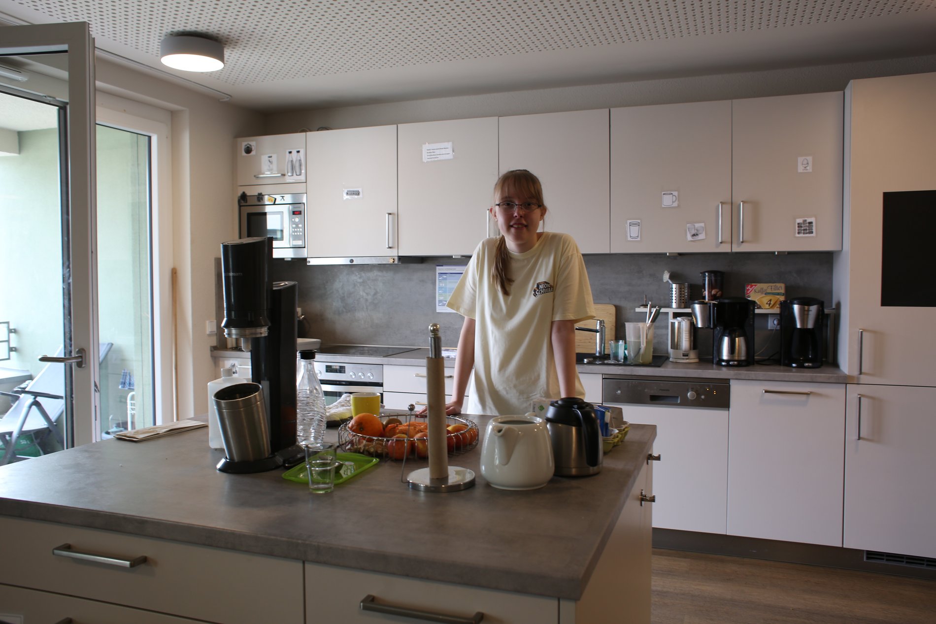 Eine Frau steht an einer Arbeitsfläche in einer Küche.