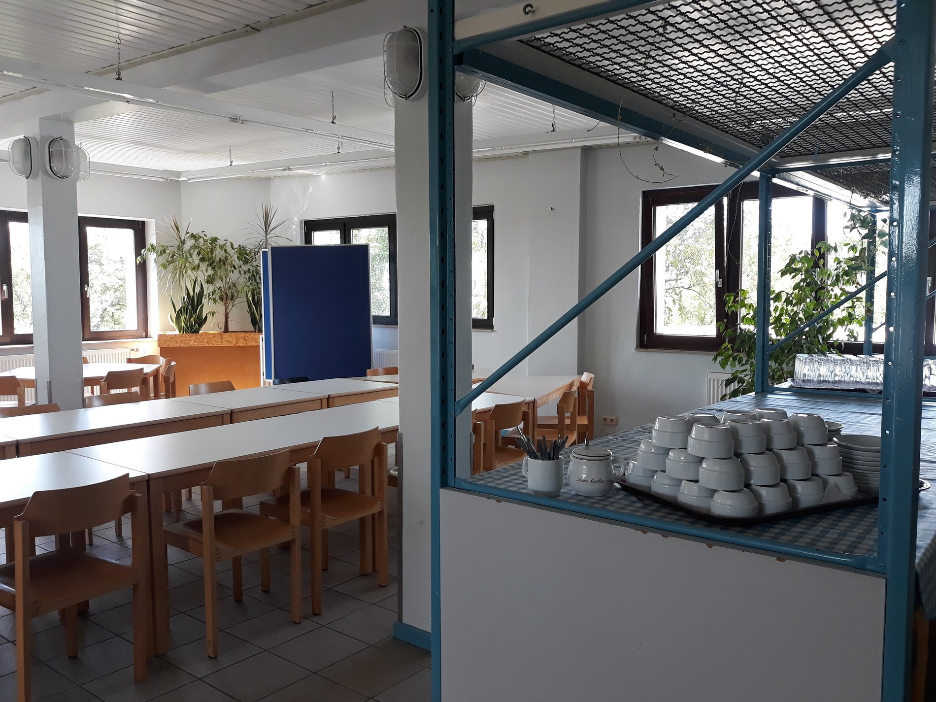 Ein Café mit Holztischen und einer Bar im KJT Salzgitter.