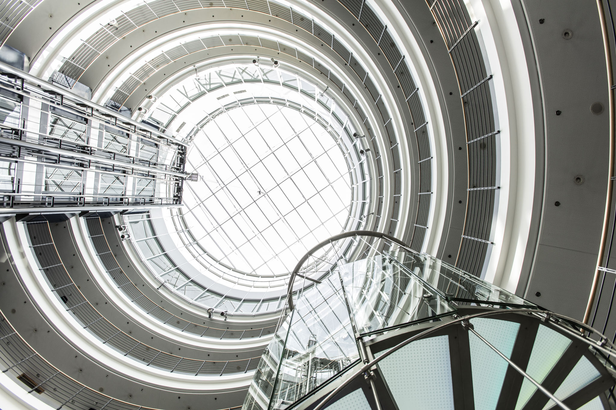 Ein verglastes rundes Gebäude, von unten nach oben fotografiert.