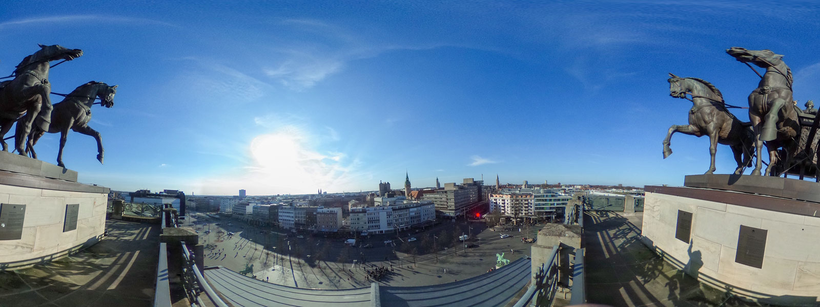 Panoramabild mit zwei Pferdestatuen im Vordergrund
